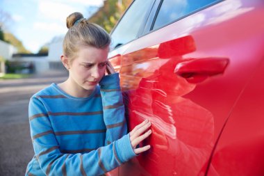 Genç Endişeli Genç Kadın Sürücü Kazadan sonra Hasarlı Arabaya Bakıyor 