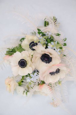 Beyaz şakayıkların, karanlık merkezlerin, yumuşak pembe çiçeklerin ve narin yeşilliğin sergilendiği çarpıcı bir düzen, doğal zarafet ve basitlik sergiliyor..