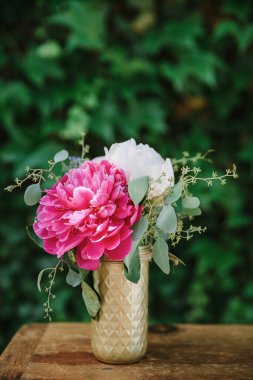 Şık bir vazoda duran pembe ve beyaz şakayık demeti yeşilliklerin arasına taze ve canlı bir dokunuş ekler..