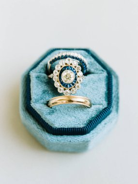 Two stunning vintage rings are showcased in a soft blue velvet box, perfect for a romantic occasion or engagement. clipart