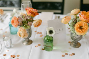 Çeşitli vazolarda taze çiçekler zarif dekorlu özel bir toplantı için büyüleyici bir atmosfer yaratır..