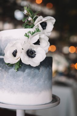 Bu nefis iki katlı düğün pastası aydınlıktan karanlığa pürüzsüz bir gradyan içeriyor, güzel beyaz çiçeklerle süslenmiş. Yumuşak ışıklandırılmış bir mekanda romantik bir atmosfer yakalar..