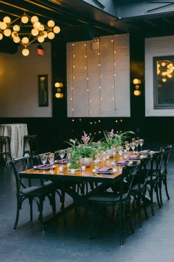 Çok güzel düzenlenmiş bir yemek masasında, çevre aydınlatmalı çağdaş bir mekanda zarif cam eşyalar ve çiçekli süsler sergilenir. Akşam toplantıları için mükemmel..