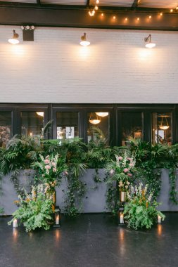 Dekoratif iç mekanda canlı bitkiler, zarif çiçek düzenlemeleri ve sıcak ışıklandırma yer alarak toplantı ve etkinlikler için hoş bir atmosfer yaratılıyor. Yeşillik modern dekoru geliştirir..