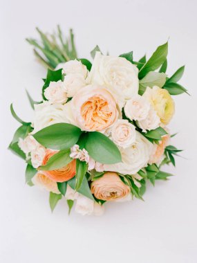 Pastel güllerin, narin çiçeklerin ve yemyeşil çiçeklerin bulunduğu çarpıcı bir buket. Her tür kutlama ve etkinlik için mükemmel..