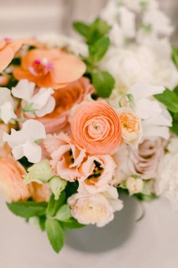 Turuncu ve beyazın yumuşak tonlarında canlı çiçekler modern ortamda davetkar bir bahar atmosferi yaratır..