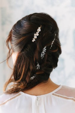 Saç örgüleri ve parlak iğnelerle çok güzel şekillendirilmiş. Düğünler ve resmi etkinlikler için mükemmel..