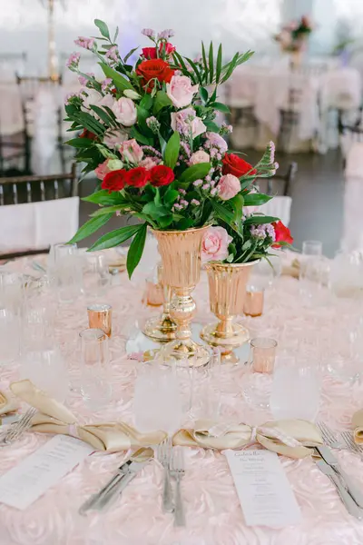 Altın vazolardaki canlı çiçekler iyi hazırlanmış bir ziyafet masasında davetkar bir ortam yaratır..