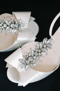 Zarif beyaz topuklar nefes kesici parlak mücevherlerle süslenmiş, özel durumlar ve kutlamalar için ideal..