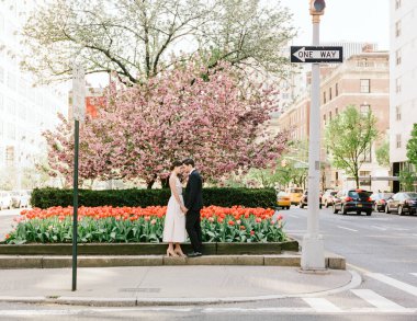 Bir çift bir arada durur, canlı laleler ve baharda açan kiraz ağacı arasında bir anı paylaşırlar..