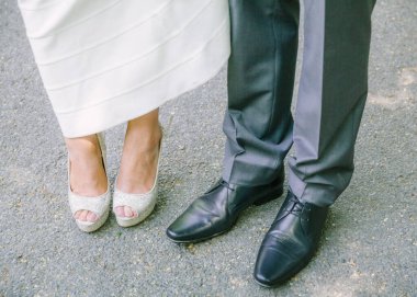 Yakın çekim, doğadaki neşeli düğün kutlamaları sırasında bir çiftin şık ayakkabılarını ön plana çıkarır..