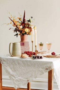 Şen şakrak bir toplantı için çiçeklerle, içkilerle ve hamur işleriyle dolu güzel bir masa..