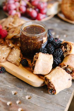 Bir tatlı tahtasında, böğürtlenli ve ahşap hamurlu incir reçeli var..