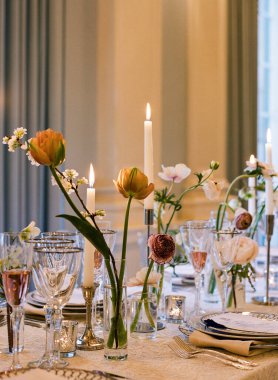 Çiçek süsü ve mum ışığı akşam yemeği için sıcak bir ortam yaratır..