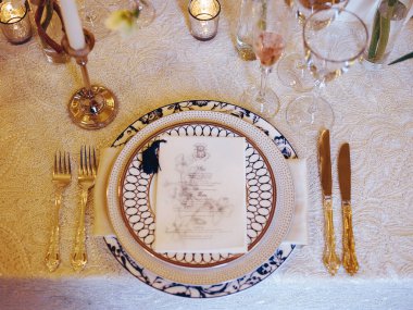 Karmaşık porselenleri, ışıltılı bardakları ve nefis bir yemek deneyimi için ince bir menüsü olan zarif bir masa..