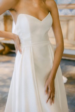 Gelin zarif straplez gelinliğini büyüleyici bir mekanda hazırlıyor, önlerindeki özel güne hazırlanıyor..