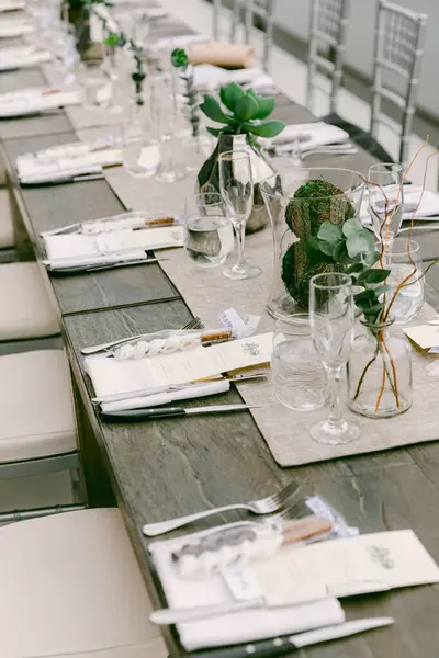 Çağdaş bir ortamda unutulmaz bir toplantı için güzel hazırlanmış cam eşyalar ve bitkiler..