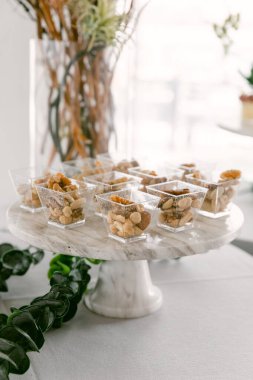 Fındık ve malzemelerle dolu lezzetli tatlı fincanları bir etkinlikte şık bir mermer tezgahta düzenlenir..