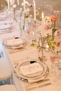 Mumlar ve çiçekli güzel bir yemek masası misafirler için davetkar bir ortam yaratır..