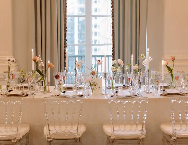 Çiçeklerin ve mumların yer aldığı güzel düzenlenmiş yemek masası güzel aydınlatılmış bir yerde şık bir ambiyans sergiliyor..