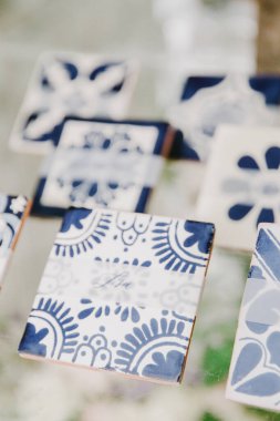 Yerel bir zanaat pazarında sergilenen seramik bardak altlıkları ve karmaşık mavi tasarımlar..