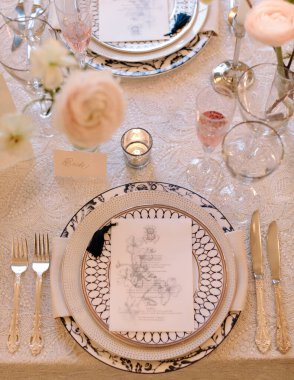 Ayrıntılı porselenler, zarif çatal bıçak takımı ve narin çiçekler içeren nefis bir sofra. Özel bir etkinlik için mükemmel..