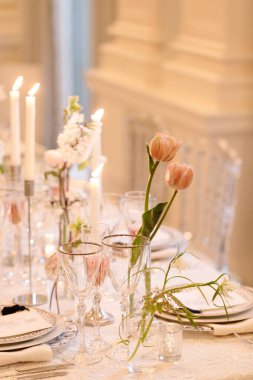 Çiçeklerin, mumların ve özel bir durum için hazırlanmış zarif bir yemek masası..