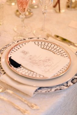 Dekoratif tabaklar, çatal bıçak takımı ve menü kartı çok güzel hazırlanmış. Resmi bir yemek için mükemmel..