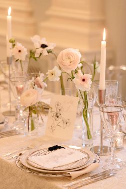 Çiçeklerle dolu güzel bir masa, şık yemek takımı, ve romantik bir his için yumuşak mum ışığı..