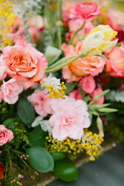Güller ve laleler de dahil olmak üzere renkli çiçeklerin çarpıcı bir görüntüsü, kırsal bir ahşap kabı doldurur, bir bahar buluşmasında veya kutlamalarda atmosferi aydınlatır..
