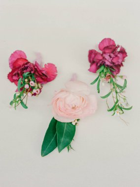 Pembe ve mor çiçeklerle süslenmiş üç zarif çiçek, düğünler ve resmi etkinlikler için mükemmel..