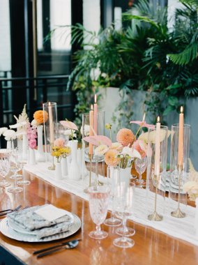 Sofistike bir mekanda güzel düzenlenmiş yemek masası çiçek süslemeleri ve göz kırpan mumlar sergiliyor. Kutlama ya da toplanma için ortam ideal..