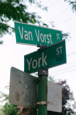 Van Vorst Caddesi ve York Caddesi 'nin kesişiminde yeşil ağaçlarla çevrili iki sokak tabelası var..