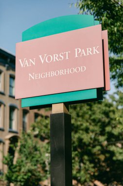 Van Vorst Park 'ı gösteren bir tabela yemyeşil ve tarihi binalar açık bir günde arka planda..