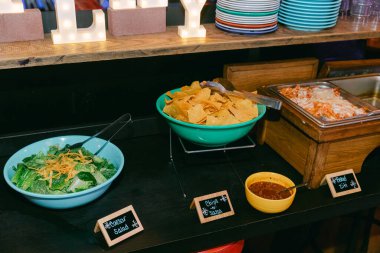 Canlı bir açık büfe, davetkar bir etkinlikte taze salata, çıtır cips ve lezzetli salsa sosu sunar..
