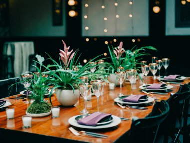 Çiçekli yemek masası, pırıl pırıl cam süsler ve yumuşak ışıklar davetkar bir hava yaratır..