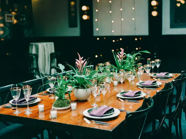 Mor aksanlı ve çiçekli güzel bir yemek masası gece sıcak bir ortam yaratır..