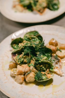Taze deniz ürünleri salatası, otlar ve yeni patatesler. Güzel bir restoranda ustalıkla sunuluyor..