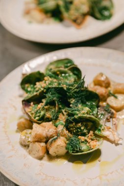 Taze deniz ürünleri salatası, otlar ve yeni patatesler. Güzel bir restoranda ustalıkla sunuluyor..