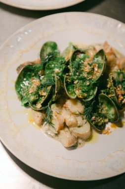 Midyeler ve taze sebzeler güzel bir tabakta sergileniyor. Güzel yemek sanatları sergiliyorlar..