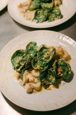 Canlı sebzeler ve otlarla birlikte taze deniz ürünleri davetkar bir restoran atmosferinde servis edilir..