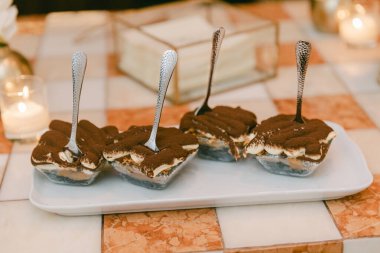 Tiramisu, akşam yemeği atmosferinde mum ışığıyla aydınlatılmış bir tabakta güzelce hazırlanmış tatlılar sunar..