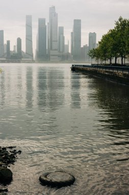 Suyun üstünde gökdelenler yükselirken sakin bir nehir kıyısı şafak vakti şehirde bir huzur anı sunuyor..