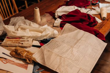 Dikiş malzemeleri, desenler ve kumaş karışıklığı ahşap masa, yaratıcı bir atmosfer yakalamak öğleden sonra zanaat.