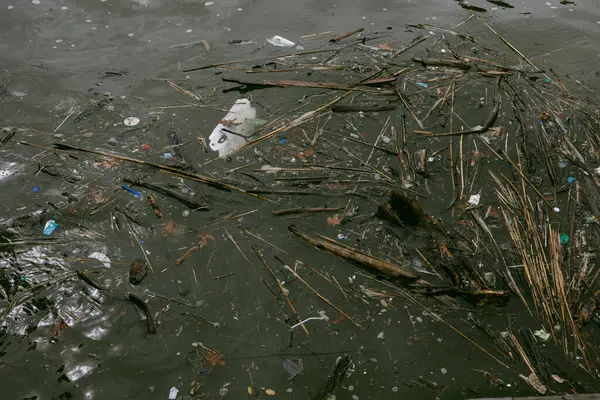 Enkaz ve plastik yığını kirlenmiş bir nehir, kentsel çevre sorunlarını gözler önüne seriyor.