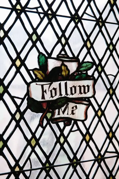 Lekeli cam ayrıntılı geometrik desen ve yeşillik aksanıyla çevrili bir 'Beni İzle' mesajı içerir.