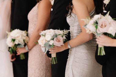 Nedimeler bir arada dururlar, her biri bir buket soluk çiçek taşır, düğün kutlaması için şık kıyafetler giyerler..