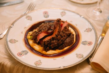 Lezzetli et dilimleri pürüzsüz patates püresi üzerinde, lezzetli sosla süslenmiş zarif bir yemek deneyimi için..