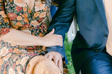 Bir çift, çiçek süslemeleriyle çevrili bir açık hava düğününde el ele tutuşmaktan hoşlanır..