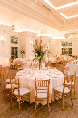 Güzel düzenlenmiş bir yemek salonunda zarif masalar, çiçekli süsler ve geceleri lüks bir atmosfer bulunur..